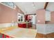 A view of a spacious kitchen featuring bright red cabinets, terra cotta tile flooring, and stainless steel appliances at 1175 Kingsley Ne Cir, Atlanta, GA 30324