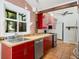 View of kitchen with bright red cabinets, stainless steel appliances, tile flooring, and a view from the kitchen window at 1175 Kingsley Ne Cir, Atlanta, GA 30324