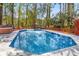 Backyard swimming pool with a red wooden deck, hot tub, and wooded backdrop at 1175 Kingsley Ne Cir, Atlanta, GA 30324