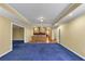 Bright living room features blue carpet, recessed lights, and a wet bar for entertaining guests in style at 10890 Regal Forest Dr, Suwanee, GA 30024