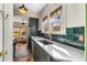 Galley kitchen featuring green cabinets, quartz countertops, copper faucet, and tile backsplash at 333 Drexel Ave, Decatur, GA 30030