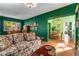 Open-concept living room with dark green walls that leads to the dining area and wood floors at 333 Drexel Ave, Decatur, GA 30030