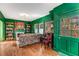 Inviting living room with rich green walls, hardwood floors, built-in bookshelves, and tapestry art at 333 Drexel Ave, Decatur, GA 30030