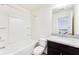 Bathroom featuring single sink with dark cabinets, and a shower over tub at 992 Belfry Ter, Fairburn, GA 30213