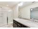 Bathroom featuring double sinks with dark cabinets, glass shower and large mirror at 992 Belfry Ter, Fairburn, GA 30213
