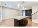 Open kitchen features a granite island with pendant lighting and access to the living room and the staircase at 992 Belfry Ter, Fairburn, GA 30213