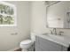 Well-lit powder room with a gray vanity, marble countertop, modern fixtures, and neutral walls at 130 Cauley Club Ct, Johns Creek, GA 30097
