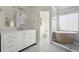 Elegant bathroom with double vanity, soaking tub, and walk-in shower with glass door at 130 Cauley Club Ct, Johns Creek, GA 30097