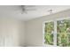 Bedroom with neutral walls, a ceiling fan, and a window overlooking the backyard at 130 Cauley Club Ct, Johns Creek, GA 30097