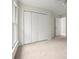 Sunlit bedroom with a large window, neutral walls, and closet space offers comfort and storage at 130 Cauley Club Ct, Johns Creek, GA 30097