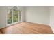 Sun-filled bedroom featuring hardwood floors and a large window overlooking the yard at 130 Cauley Club Ct, Johns Creek, GA 30097