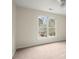 Bright bedroom features a large window overlooking the exterior, neutral walls, and carpeted flooring at 130 Cauley Club Ct, Johns Creek, GA 30097