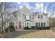 Beautiful two-story brick home with manicured landscaping and a red front door at 130 Cauley Club Ct, Johns Creek, GA 30097