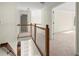 Upstairs hallway with wood railing overlooks the living area, leading to bedrooms and bathrooms at 130 Cauley Club Ct, Johns Creek, GA 30097