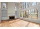 Open-concept living room with hardwood floors, fireplace, and large windows offering natural light at 130 Cauley Club Ct, Johns Creek, GA 30097