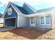 Charming home exterior with two-car garage, gray siding, and a covered front porch with wooden support beams at 33 Cambridge Ln, Dallas, GA 30157