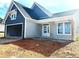 Charming home exterior with two-car garage, gray siding, and a covered front porch with wooden support beams at 33 Cambridge Ln, Dallas, GA 30157