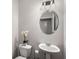 Elegant powder room featuring oval mirror, pedestal sink, and decorative flower accent at 4358 White Spruce Aly, Doraville, GA 30360