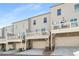 Townhome exterior featuring individual driveways, garages, and elevated decks on a sunny day at 4358 White Spruce Aly, Doraville, GA 30360