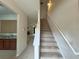 Carpeted staircase with white railing and post newel, open to the living room and kitchen at 585 Mcwilliams Se Rd # 2602, Atlanta, GA 30315