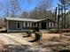 Charming single-story home with a metal roof and a partially wooded front yard at 8090 Colquitt St, Douglasville, GA 30134