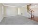 Open-concept living room featuring neutral walls, staircase and hardwood entryway creating a welcoming space at 1056 Shadow Lake Dr, Lithonia, GA 30058