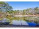 Scenic pond with a charming gazebo and wooden walkway surrounded by lush greenery, creating a tranquil escape at 1056 Shadow Lake Dr, Lithonia, GA 30058
