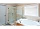 Bright bathroom featuring a tub, glass shower, and large garden tub at 1416 Rockview Ln, Loganville, GA 30052