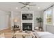 Bright living room features a fireplace, modern decor, lots of natural light, and a ceiling fan at 1456 Auburn Glen Rd, Dacula, GA 30019