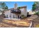 Exterior view of the home's back, featuring a raised deck and concrete patio, and garden steps at 2425 Pemberton Pt, Buford, GA 30519
