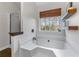 Relaxing bathroom showcasing a soaking tub next to a window, complemented by wooden shelves at 2425 Pemberton Pt, Buford, GA 30519
