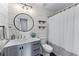 Stylish bathroom with shiplap walls, updated vanity, round mirror, and a shower-tub combination at 2425 Pemberton Pt, Buford, GA 30519