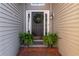 Inviting entryway with a dark front door, decorative wreath, and potted ferns at 2425 Pemberton Pt, Buford, GA 30519