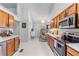 Spacious kitchen leading to seating area, featuring stainless steel appliances and modern finishes at 2425 Pemberton Pt, Buford, GA 30519