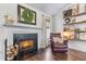 Cozy fireplace with mantel and brick surround next to a leather armchair at 2425 Pemberton Pt, Buford, GA 30519