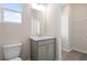 Well-lit bathroom featuring a modern vanity, toilet, and view of a walk-in closet for added convenience at 108 Black Gum Unit 38 Ln, Auburn, GA 30011