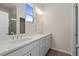 Bathroom featuring double vanity, quartz counters, white cabinetry, and large mirror with modern lighting at 108 Black Gum Unit 38 Ln, Auburn, GA 30011