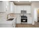 Modern kitchen with white cabinets, marble countertops, stainless steel appliances, and stylish fixtures at 108 Black Gum Unit 38 Ln, Auburn, GA 30011