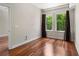 Bedroom featuring hardwood floors, two windows with curtains, and an open doorway at 201 W Ponce De Leon Ave # 315, Decatur, GA 30030
