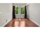 Bright bedroom with hardwood floors, white trim, and two windows with dark curtains at 201 W Ponce De Leon Ave # 315, Decatur, GA 30030