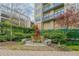 Relaxing courtyard with outdoor seating beneath an umbrella surrounded by mature trees and flowering shrubs at 201 W Ponce De Leon Ave # 315, Decatur, GA 30030