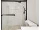 Elegant bathroom shower enclosed with clear glass, mosaic tile floor, and updated fixtures at 2216 Marbut Farms Trce, Lithonia, GA 30058