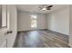 Cozy bedroom featuring neutral walls, gray wood-look flooring, and a ceiling fan for added comfort at 2216 Marbut Farms Trce, Lithonia, GA 30058