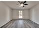 Spacious bedroom with modern ceiling fan and large window, providing ample natural light and stylish gray wood floors at 2216 Marbut Farms Trce, Lithonia, GA 30058