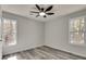 Light-filled bedroom with gray wood-look flooring, neutral walls, and a ceiling fan for added comfort at 2216 Marbut Farms Trce, Lithonia, GA 30058