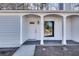 Close-up of the front porch with white columns and trim, a white front door with a glass insert at 2216 Marbut Farms Trce, Lithonia, GA 30058