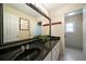Bathroom with black countertops, double sinks, and large mirror at 5960 Camelia Dr, Douglasville, GA 30135
