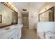 Bathroom featuring dual sinks, large mirrors, and a separate shower stall at 5960 Camelia Dr, Douglasville, GA 30135