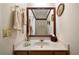 Bathroom featuring a single sink vanity, decorative mirror, and neutral color scheme at 5960 Camelia Dr, Douglasville, GA 30135
