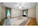 Large Primary bedroom featuring a tray ceiling, ceiling fan, hardwood floors and large area rug at 5960 Camelia Dr, Douglasville, GA 30135